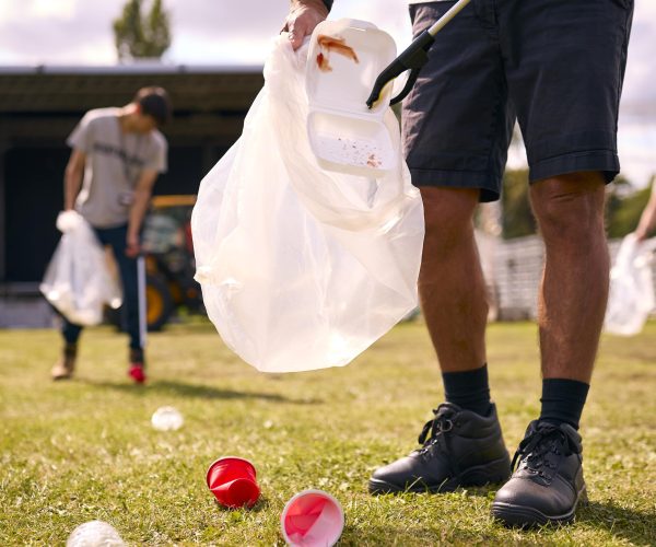 close-up-of-volunteers-picking-up-litter-after-out-2024-10-22-11-39-54-utc-min